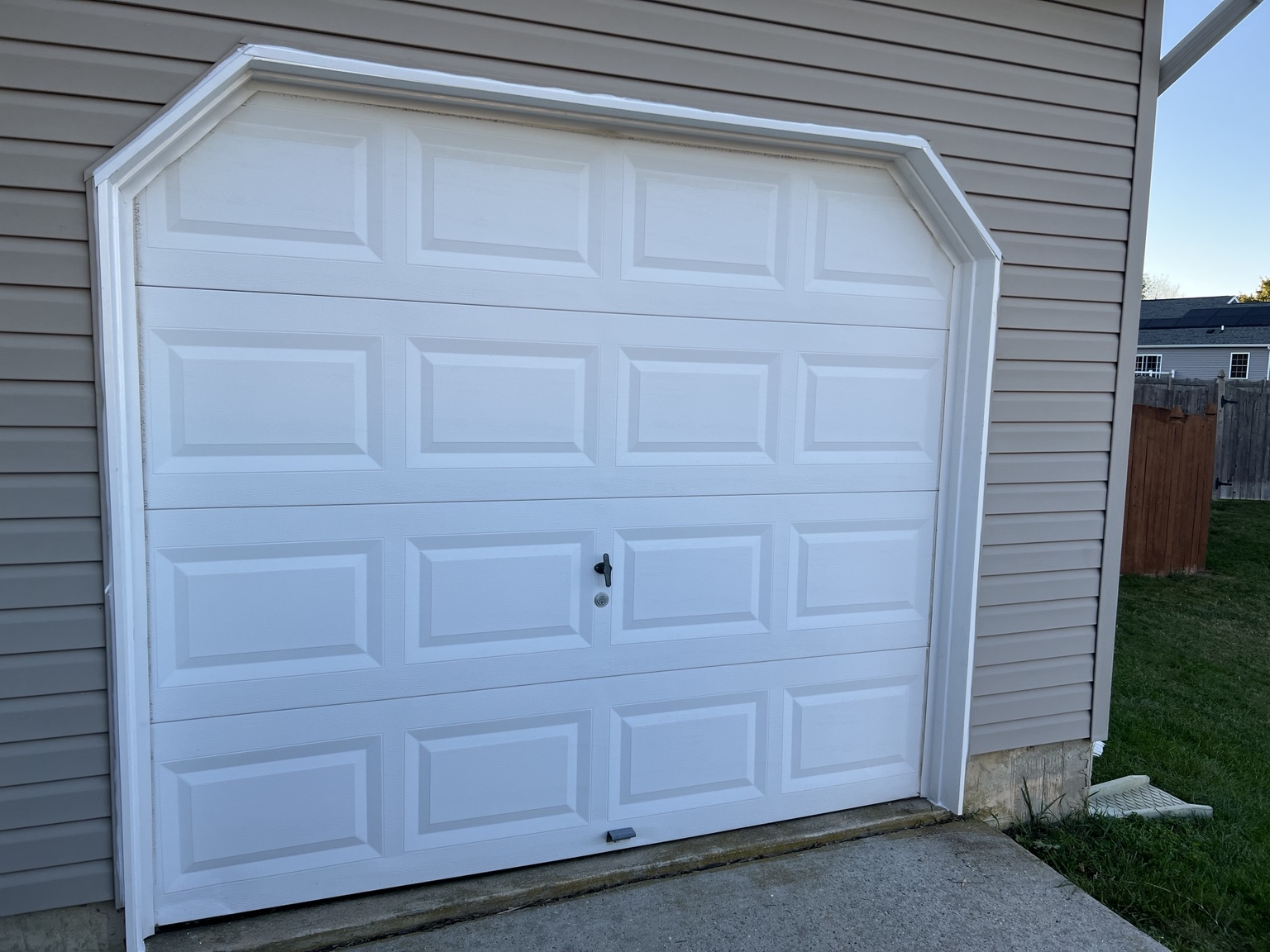 Finished white garage door with newly completed exterior trim